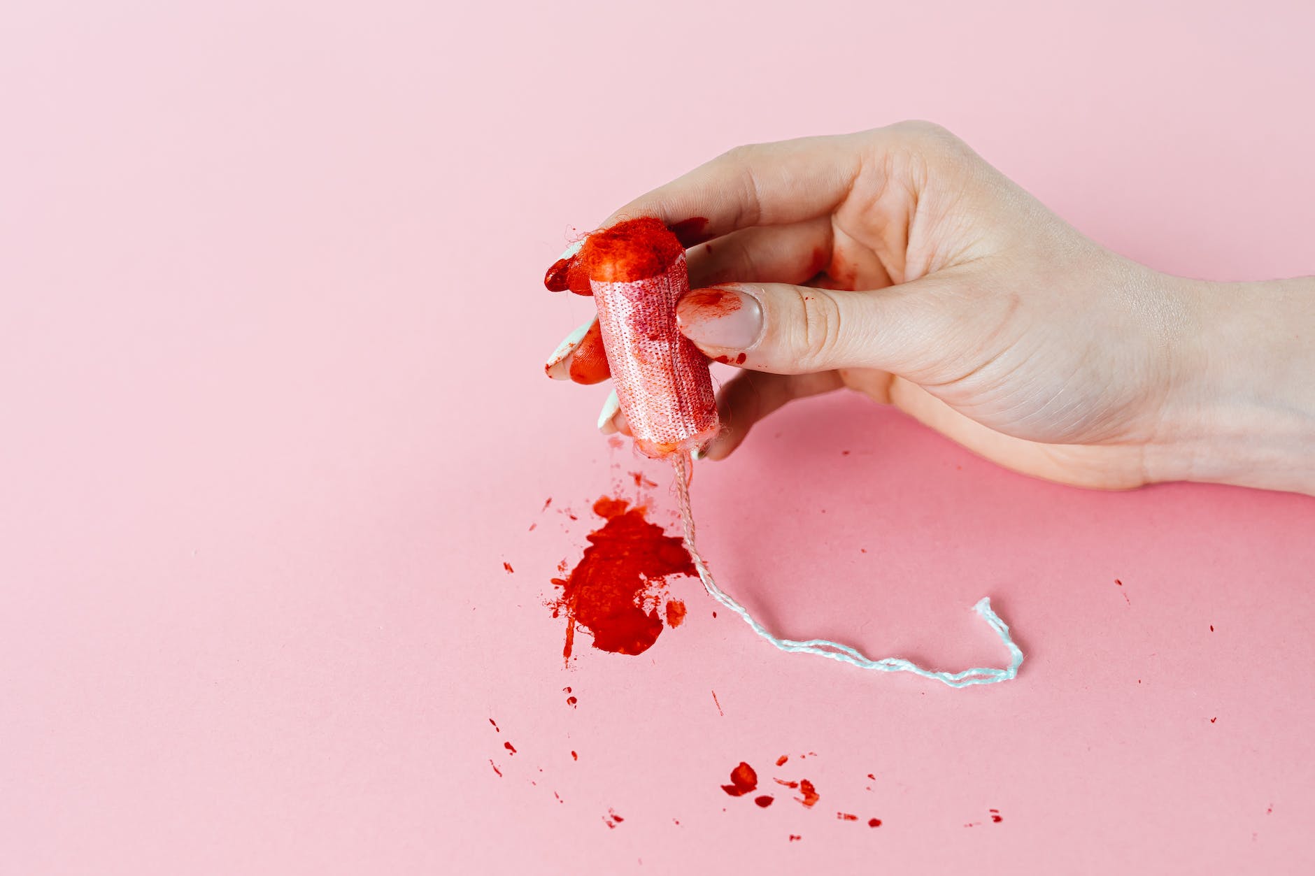 photo of a tampon with blood stains being held Is it Safe to Have Sex Within a Few Days After Your Period Ends? (Safe Sex and the Menstrual Cycle)